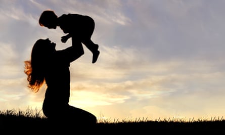 Silhouette of happy mother playing outside with a child