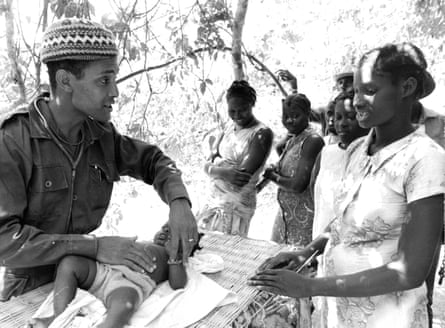 A Cuban doctor examines a child whose mother had brought him for an examination with abdominal pain in Guinea.