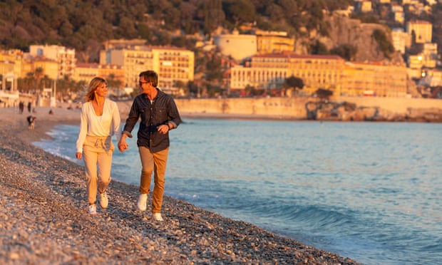 Un couple marchant sur la plage de Nice.