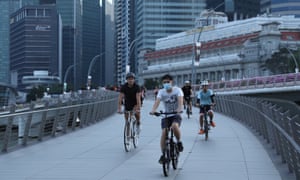  People wearing face masks as a preventive measure ride bicycles along the Jubilee Bridge in Singapore.
