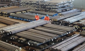 Workers check steel products at a factory in Dalian, China