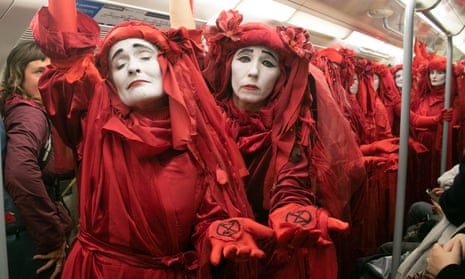 Red rebels from Extinction Rebellion ride on the London Underground.