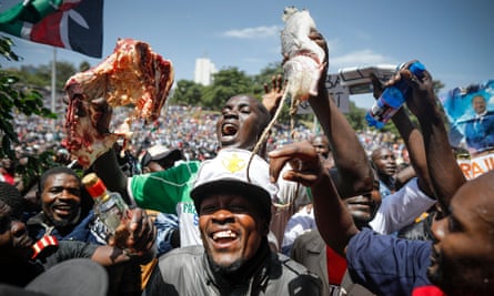 A supporter of Raila Odinga holds up a piece of meat and fish during the ‘swearing-in’ ceremony in Nairobi.