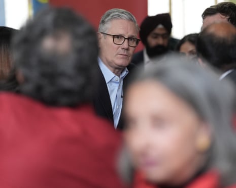 Starmer stands in focus among a blurred crowd