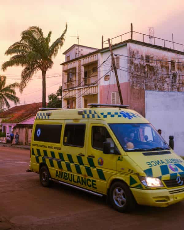 An ambulance drives passes in downtown Bissau.