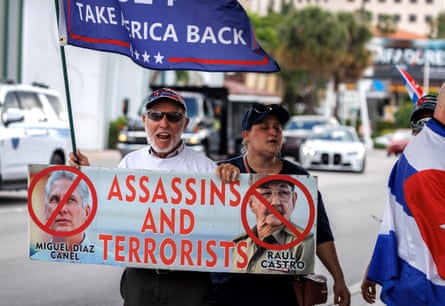 demonstrators hold signs against the cuban government