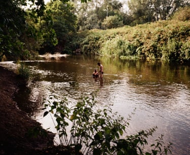 The River Lea pictured from the riverbank, two people in the water