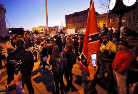 Supporters of Joseph Biden march for voting rights past supporters of U.S. President Donald Trump carrying Confederate flags in Graham, North Carolina.