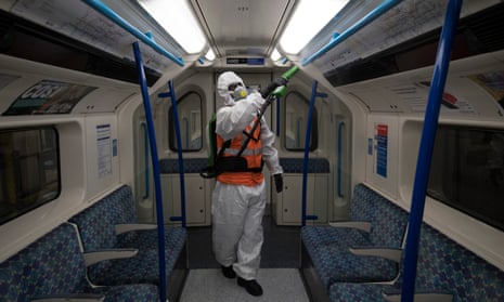 A TfL worker sprays antiviral solution inside a tube train.