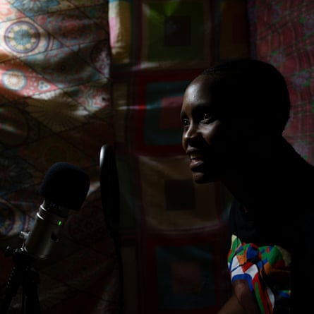 Mats’eliso Tsekoa speaking into a microphone against a backdrop of heavy patterned drapes