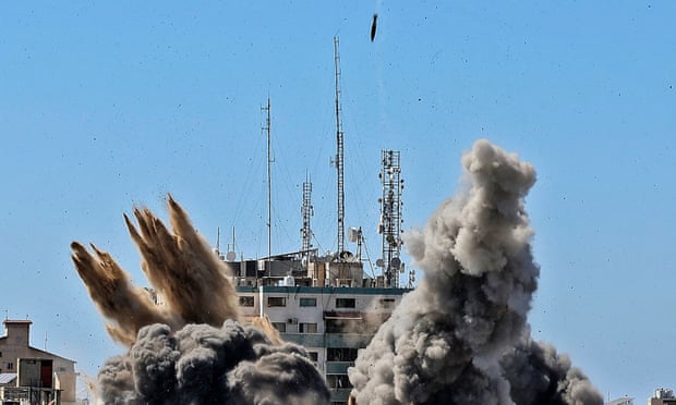 Smoke billows as a bomb is dropped on the Jala Tower during an Israeli airstrike in Gaza City on 15 May
