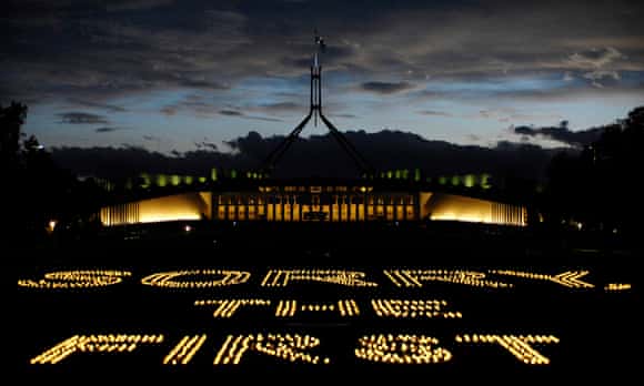 Candles spell out 'Sorry the first step' in front of Parliament House