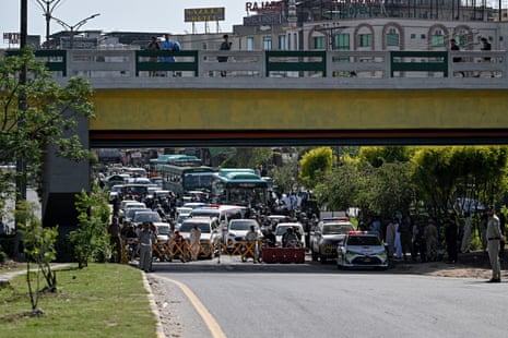 Security personnel halt traffic as motorcade vehicles carrying US security officials make their way toward the venue.