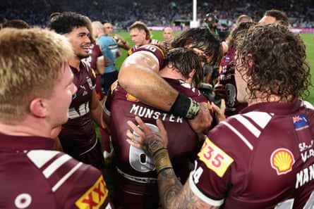 Cameron Munster of the Maroons is embraced by teammates
