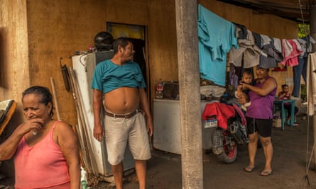 Nanda Morales, 59 (pink shirt), and Rosendo Garcia, 55 (turquoise shirt), in the provisional house to which they were forced to move with Luisa (purple shirt) and their children.