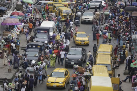 Pedestrians shop at a market in Lagos, Nigeria.