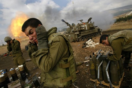 Soldiers cover their ears as an artillery unit fires shells
