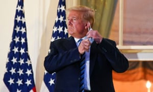 US President Donald Trump pulls off his face mask as he returns to the White House after being hospitalised at Walter Reed Medical Center for coronavirus disease (COVID-19), in Washington.