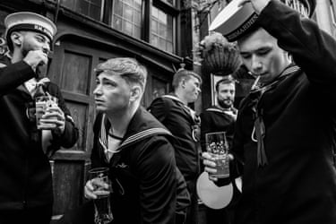 A group of submariners drink beer outside a pub