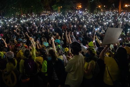 Protesters hold cellphone lights as they gather at the justice center and courthouse as feds attempt to intervene after weeks of protests in Portland.