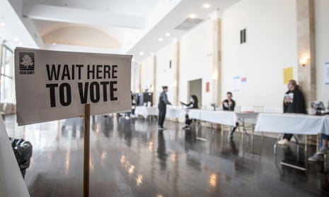 sign saying wait here to vote in a big room