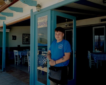 A young man in a blue T-shirt stands at the entrance of the Four Seasons restaurant