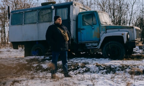 Mykola Hrechukha stands in the snow in front of an old truck