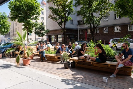 People sitting on benches in a small urban parklet