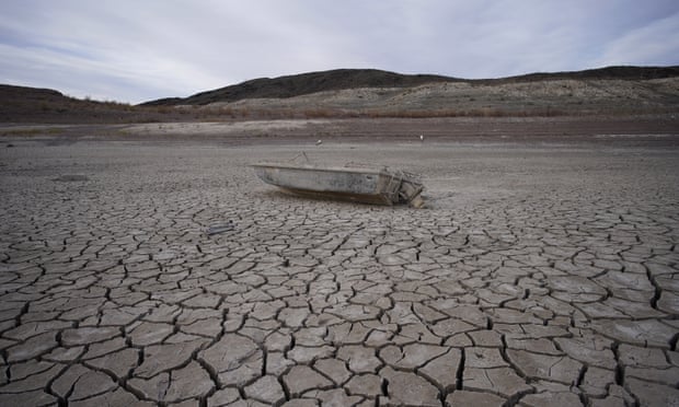 A formerly sunken boat sits on cracked earth hundreds of feet from the shoreline of Lake Mead