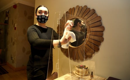 The spa treatments manager at Cottons Hotel and Spa in Knutsford, Cheshire, cleans a protective screen before its reopening after the end of the second English lockdown