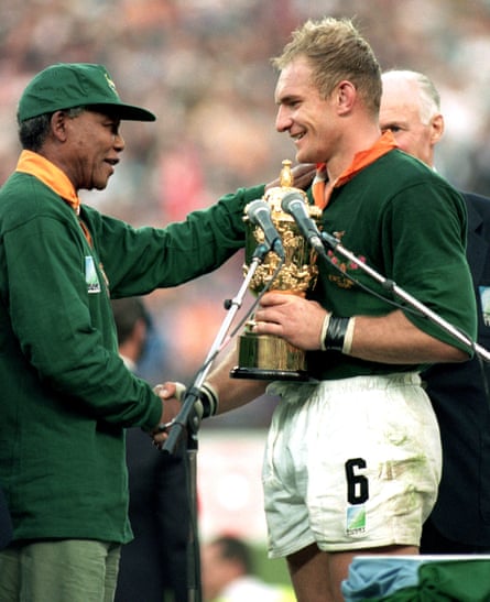 Captain Francois Pienaar of South Africa receives the William Webb Ellis Cup from the South African President, Nelson Mandela after the Rugby World Cup final between South Africa and New Zealand held on June 24, 1995 at Ellis Park in Johannesburg, South Africa