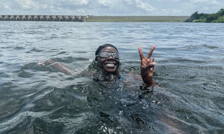 Tetteh signals victory as she reaches the end of her marathon swim down Ghana’s Volta River