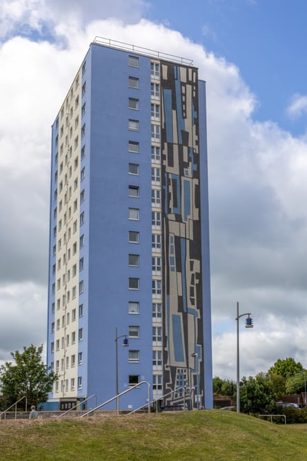 a blue high-rise building with a mural on the side wall