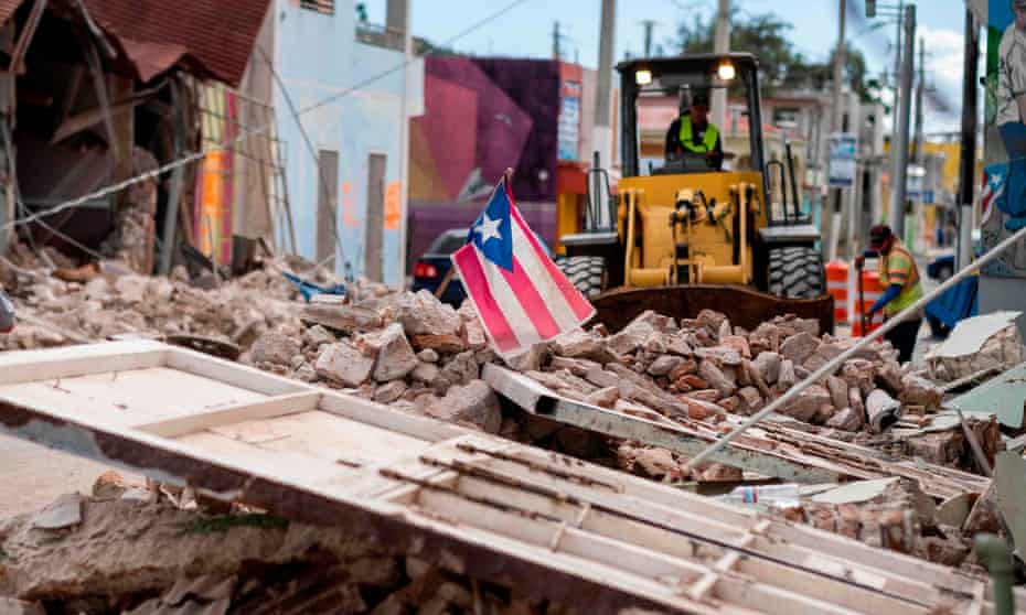 A Puerto Rican flag waves on top of a pile of rubble in Guanica.