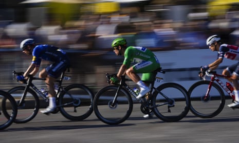 Britain’s Mark Cavendish, wearing the best sprinter’s green jersey, is lead out over the cobbles.