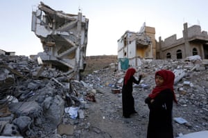 Yemeni women walk through the debris of a housing block allegedly destroyed by previous Saudi-led airstrikes, in Sana'a, Yemen, 29 September 2017