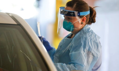 A nurse holds a nose swab at a drive-through testing site for coronavirus, flu and RSV in Seattle, Washington.