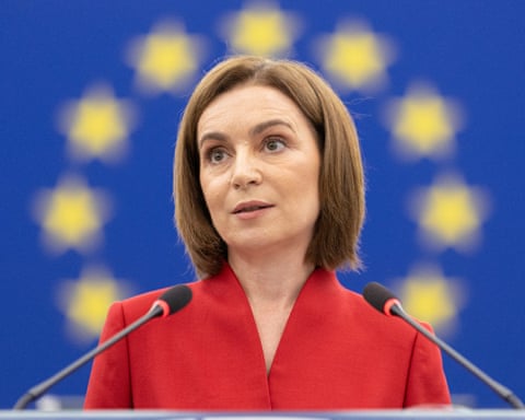 Woman stands in front of the European Union flag. dqxikeidqkikdinv