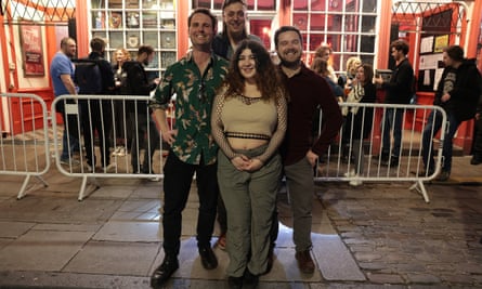 Three men and a woman pose outside the venue