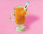 a cup of an orange fluid with a thermometer in it