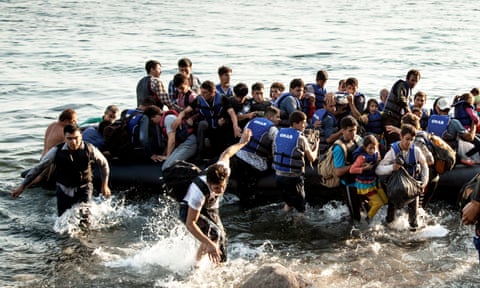 A boat dangerously overloaded with refugees lands near Molyvos on the Greek island of Lesbos, July 2015