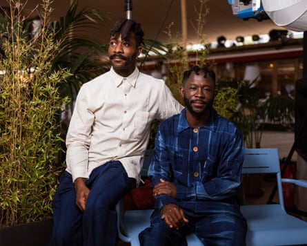 Arie and Chuko sat next to one another. Arie is wearing a cream shirt, Chuko a patterned blue shirt.