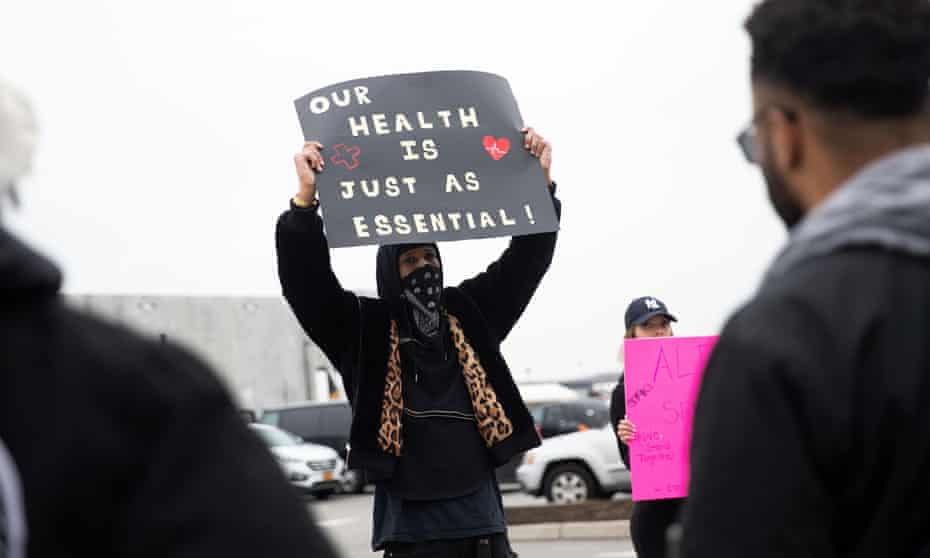 Chris Smalls holds a sign at an Amazon building on 30 March. Smalls had led a workout demanding the company shut the facility after multiple workers tested positive for Covid-19. 