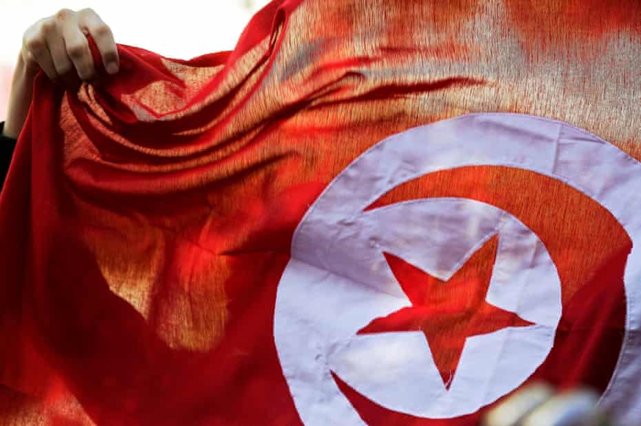 A Tunisian flag is held aloft during celebrations marking the fourth anniversary of the country’s 2011 revolution