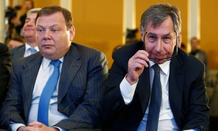 Aven and Fridman sitting next to each other at a meeting or conference, both dressed in suits