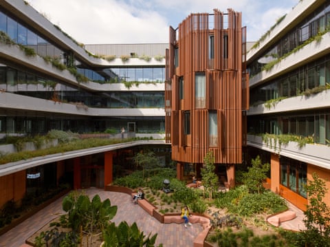 An industrial park named Bourke & Bowden in Sydney’s Alexandria. A courtyard filled with plants surrounded by an office complex with a main hub building composed of vertical slats.