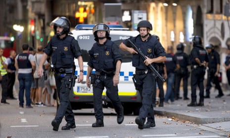Police officers near the Las Ramblas area of Barcelona after a van ploughed into a crowd, killing at least 13 and injuring more than 80 on Thursday night.