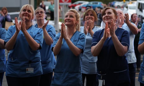 Nursing staff clap as their colleagues look out from a window at the Queen Elizabeth University Hospital in Glasgow.