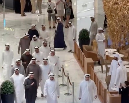 About a dozen people in Arab garb walking