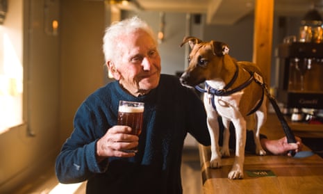 Ted Duck, a volunteer with the pub dog Oreo before the grand reopening of the Blue Bell pub in Stoke Ferry, Norfolk.